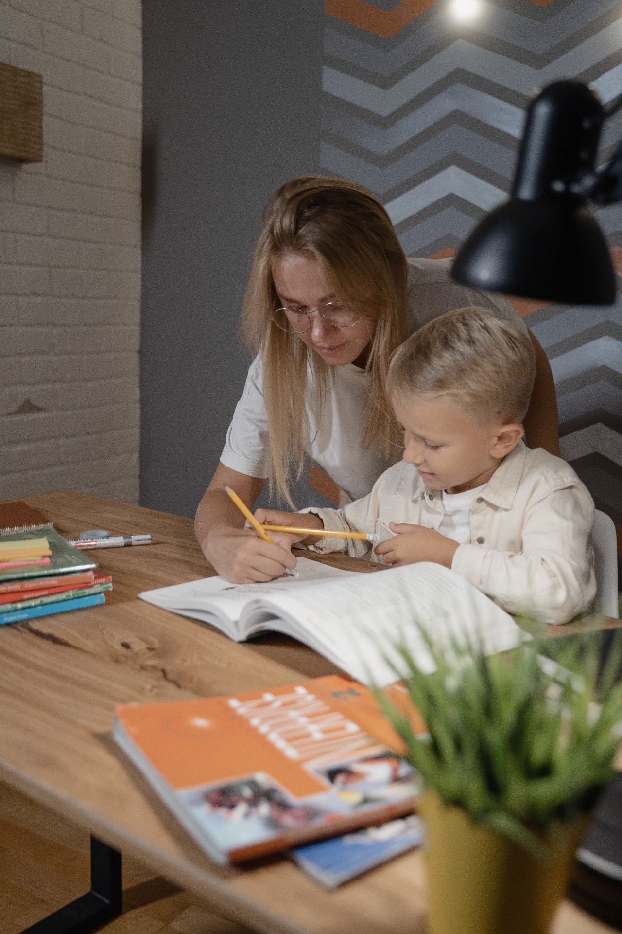 Therapist and student writing together at a desk